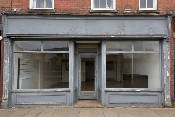Worn commercial shop front before painting and spraying in Milton Keynes