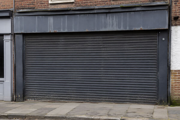 Faded roller shutter before commercial spraying in Letchworth Garden City